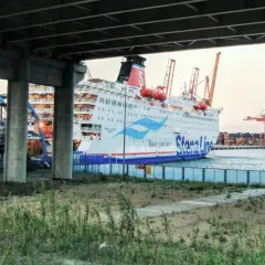 Widok na prom Stena Line w Gdyni, z dwoma mężczyznami na pierwszym planie. W tle portowe dźwigi i inne statki.