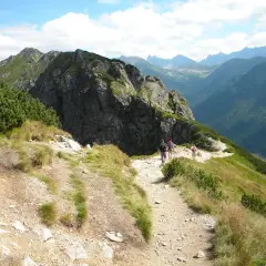 Grupa turystów wędruje malowniczym szlakiem w Tatrach. Widok na góry i doliny, idealne tatry szlaki dla średnio zaawansowanych.