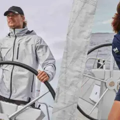 Uomo e donna con abbigliamento tecnico per barca a vela, pronti per navigare.