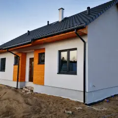 Nowoczesne domy szkieletowe na zgłoszenie, białe z drewnianymi elementami, gotowe do zamieszkania.