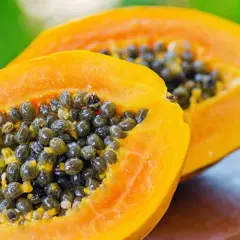 Zwei Hälften einer reifen Papaya mit vielen schwarzen Samen. Die Papaya ist bekannt für ihre verdauungsfördernde Papain-Wirkung.