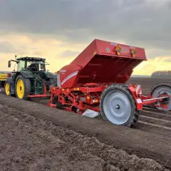 Traktor z sadzarką GRIMME sadzi ziemniaki. Optymalne ile kg sadzeniaków na 1 ha zależy od odmiany i warunków.