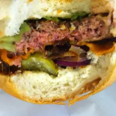 Soczysty burger z serem, sałatą, ogórkiem i cebulą. Idealny do podania po odpowiednim czasie smażenia.