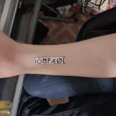 Nowy tatuaż na przedramieniu: ÌÕMPÆØË. Wygląda jak tajemniczy symbol.