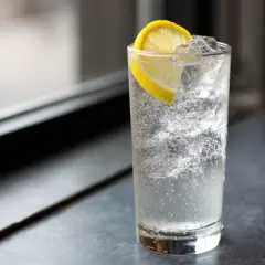 Ett glas med bubbligt vatten, is och en citronskiva. En perfekt enkel drink för en varm dag.