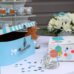 Une boîte à trésors bleue pour un baptême, avec un ours en biscuit "Merci !" et des petits pots de dragées. Une idée de gazette baptême à télécharger.