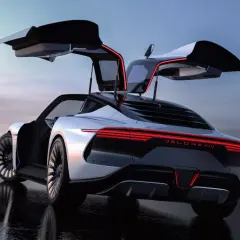 Nowoczesny DeLorean Alpha5 z otwartymi drzwiami typu gullwing, lśniącymi czerwonymi światłami, na mokrej nawierzchni.