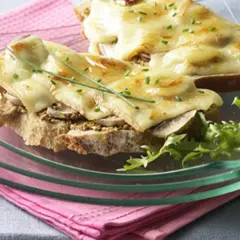 Tartines gourmandes avec une généreuse croute de fromage fondue, garnies de champignons et de ciboulette.