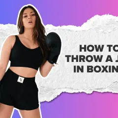 A woman in boxing gloves demonstrates how to throw a jab in boxing.