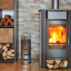 Un poêle à bois crépitant, avec du bois rangé à côté. Un accessoire pour le feu est présent.
