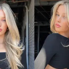 Blond włosy z subtelnym scandi hairline, falowane i pełne objętości, opadają na ramiona.