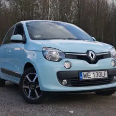 Jasnoniebieskie Renault Twingo na tle drzew. Zastanawiasz się nad jego **renault twingo spalanie**?
