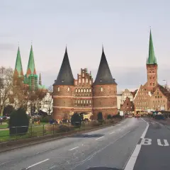 Holstentor, en ikonisk portbyggnad i norra Tyskland, med sina karaktäristiska torn och kyrkor i bakgrunden.