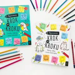 Dwie książeczki "Rysowanie krok po kroku" dla dzieci, jedna ze smokami i robotami, druga z kotami i żabami, otoczone kolorowymi kredkami.