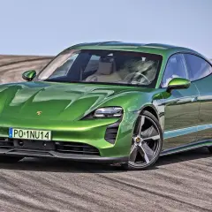 Zielony Porsche Taycan na torze, marka samochodu na P, z widocznymi śladami opon.