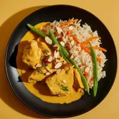 Aksamitny kurczak w sosie curry, podany z ryżem, fasolką szparagową i migdałami. Pyszne danie, które rozpływa się w ustach.