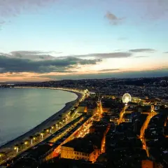 Widok na wybrzeże Nicei o zmierzchu, z oświetlonym miastem i morzem. Nawet w styczniu, Nicea oferuje piękną pogodę i widoki.
