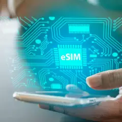 Dłoń trzyma smartfon, nad którym unosi się cyfrowy obwód z napisem eSIM. To przyszłość łączności, esim bez abonamentu.