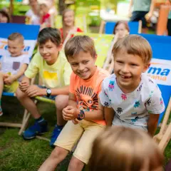 Uśmiechnięte dzieci siedzą na leżakach w parku. To idealne miejsce na letnie zabawy, jak w najlepszych parkach dla dzieci.
