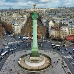 Vue aérienne de la colonne de Juillet sur la place de la Bastille, avec le trafic parisien animé autour.