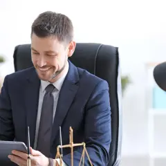 Un notaire souriant consulte une tablette, prêt pour un appel de fonds. La balance de la justice est visible.
