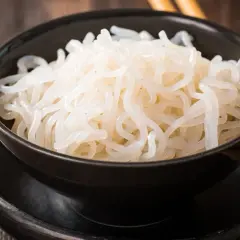 Misternie zwinięty makaron konjac w czarnej misce. To zdrowe i niskokaloryczne danie, które warto wypróbować.