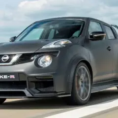 Nissan Juke-R gris oscuro, con alerón trasero y llantas deportivas, circulando por una pista.