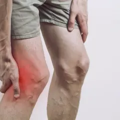 Ból w przedniej części kolana, gdzie widoczny jest zaczerwieniony guz.