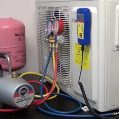 Equipo para hacer vacío a un aire acondicionado: bomba, manómetros, tanque de refrigerante y mangueras.