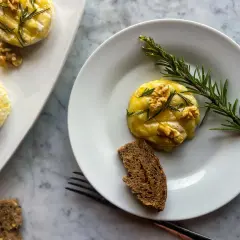 Deliziosi tomini in friggitrice ad aria, guarniti con noci e rosmarino, serviti con pane integrale.