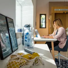 Mujer trabajando en portátil con luz natural. La luz que entra por la ventana es ideal para la vista.