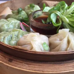 Parowóz z dim sum: zielone i białe pierożki z sosem i sałatką.