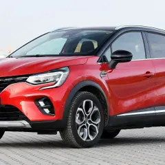 Czerwony Renault Captur na tle miejskiego krajobrazu. Zastanawiasz się, renault captur jaki silnik wybrać?
