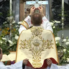 Kapłan podnosi hostię do krzyża. To nie jest czarna msza, lecz uroczysta msza święta.
