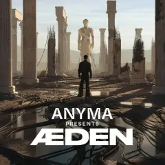 Mężczyzna stoi przed ruinami starożytnych kolumn, patrząc na gigantyczny posąg. Anyma Presents ÆDEN – zapowiedź koncertu.