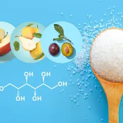 Jabłka, gruszki, śliwki i kryształki cukru na łyżce. Chemiczny wzór sorbitolu wyjaśnia, sorbitol co to jest.