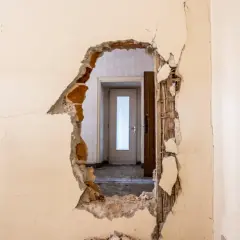 Trou dans un mur révélant une porte. Idéal pour un modèle lettre logement insalubre.