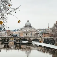 Un raro freddo a Roma imbianca il Tevere e i ponti, con San Pietro sullo sfondo.