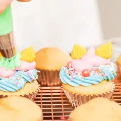 Decorazione di cupcake con crema al burro colorata, zuccherini e perline.