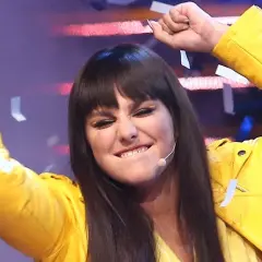 Ewa Farna w żółtej ramonesce, z uniesionymi rękami i konfetti, śpiewa "Bez łez".