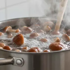 Grzyby gotują się w garnku, parując obficie. Warto wiedzieć, ile gotować grzyby, by były smaczne i bezpieczne.