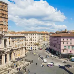 Piazza animata con la maestosa basilica di Santa Maria Maggiore a Roma, torre campanaria e colonna antica.