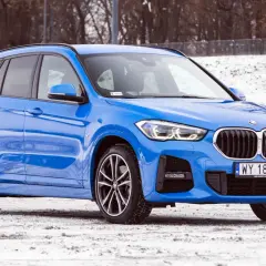 Błękitne BMW X1 2025 na śniegu, gotowe na zimowe wyzwania.