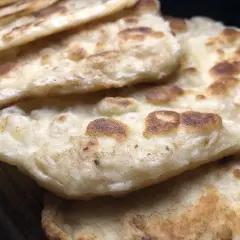 Stos chlebków naan, idealnych do indyjskich dań. Gdzie kupić świeży chlebek naan?