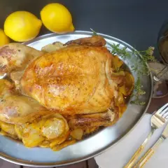 Un capón asado, jugoso y dorado, servido con patatas y limones. ¡Un festín para los sentidos!