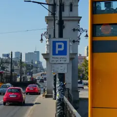 Żółty fotoradar na moście, obok znaku parkingu. Zastanawiasz się, po jakim czasie przychodzi mandat z fotoradaru?
