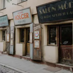 Stare szyldy sklepów w krakowskim quartiere ebraico: "Salon Mód", "Holcer Stolaz", "Stanisław Nowak Sklep Spożywczy".