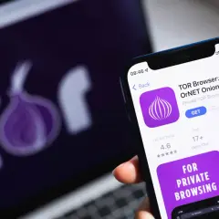 Smartfon z aplikacją TOR Browser, obok laptop z logo sieci Tor. Prywatność w sieci.