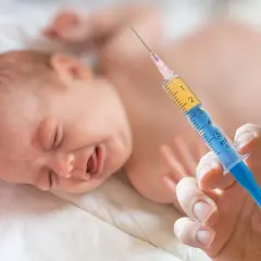 Płacz dziecka po szczepieniu, gdy w ręku trzymana jest strzykawka. Może to być gorączka po szczepieniu.