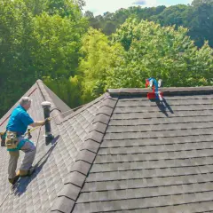 A roofer demonstrates how to shingle a steep roof, using safety gear and a ladder.
